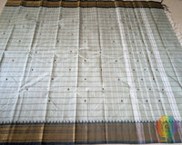 Full sage green Kanchi cotton saree laid open showcasing all-over checks design