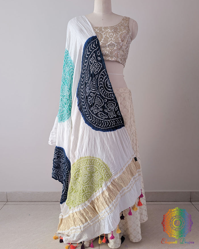 White Gajji Silk Multicolour Bandhani Dupatta in a full draped view, showcasing the white base decorated with navy blue, sea green, mauve, pink and green Bandhani motifs.