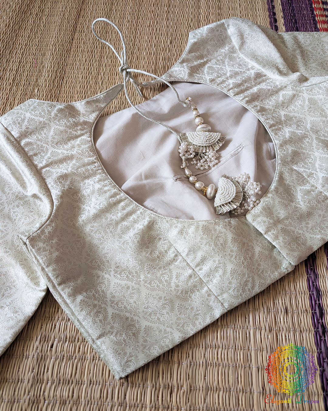 Back view of the Off White Banarasi Brocade Designer Blouse with back hook closure and pearl tassels
