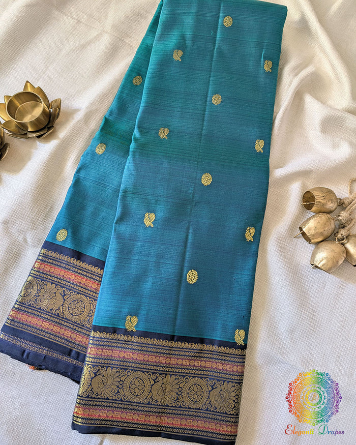 Teal Blue Pure Kanjivaram Handloom Silk Saree with 1gm Gold Zari displayed in a folded view, showcasing the rich teal blue silk and traditional golden zari detailing.
