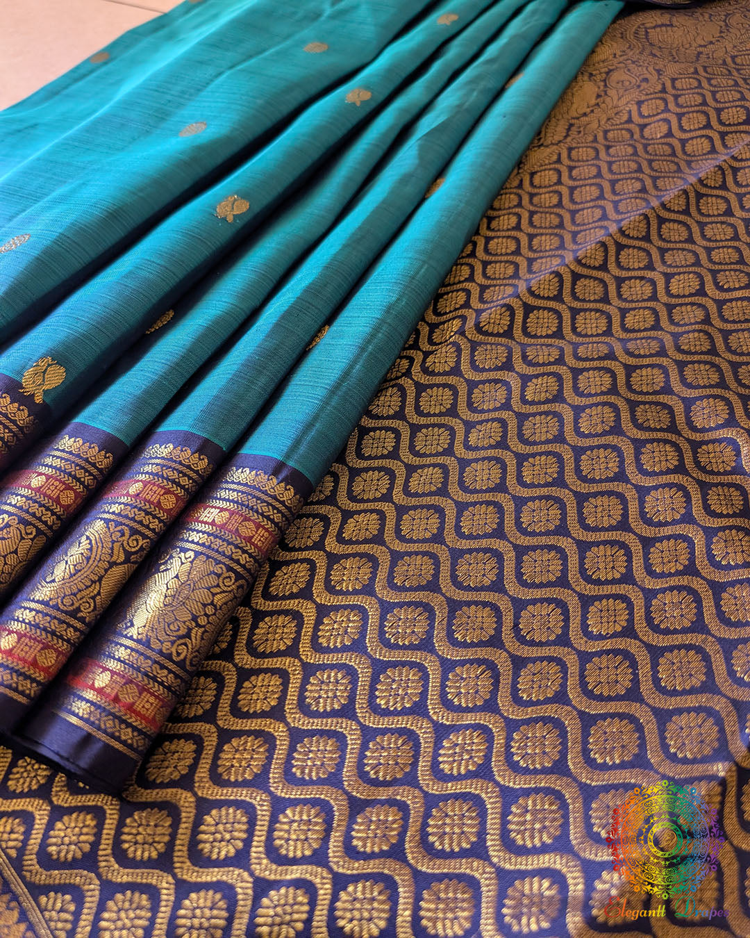 Close-up of the Teal Blue Kanjivaram Silk Saree border, highlighting the intricate gold zari weaving against the rich teal blue silk.