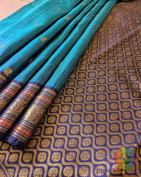Close-up of the Teal Blue Kanjivaram Silk Saree border, highlighting the intricate gold zari weaving against the rich teal blue silk.