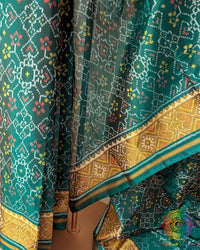 Pleats close up on turquoise Patola silk saree showcasing weave and traditional pattern
