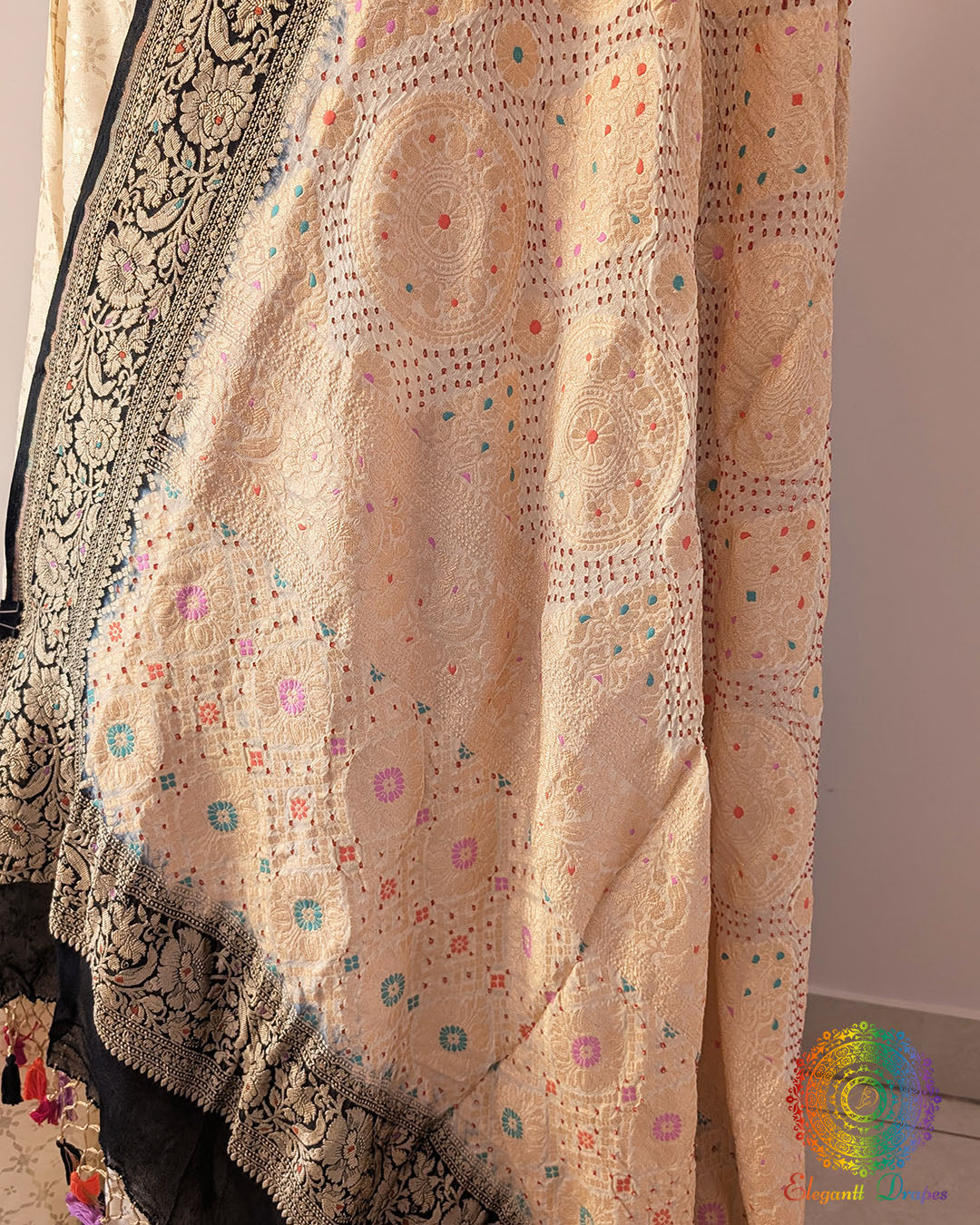 Close up of white black bandhani dupatta showing tie dye and meenakari weaving