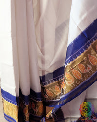 White Blue Rajkot Patola Saree – Pleats Detail View displaying the neatly arranged pleats with repeating geometric motifs, contrasting blue patterns and the natural sheen of the white mulberry silk fabric.