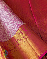 Pink zari border close up on white Kanjivaram silk saree