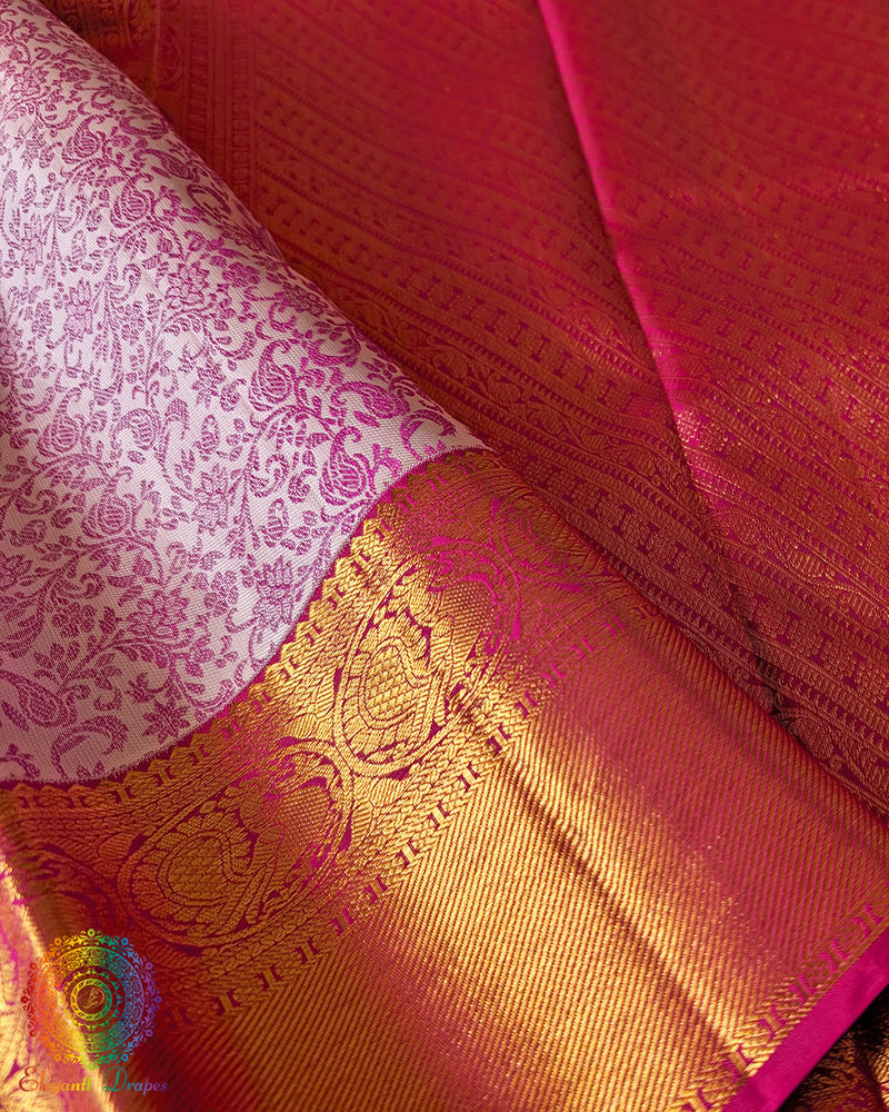 Pink zari border close up on white Kanjivaram silk saree