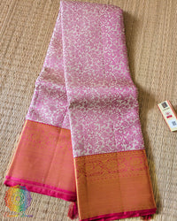 Folded white pink Kanjivaram silk saree showing pink thread weaving and zari detail