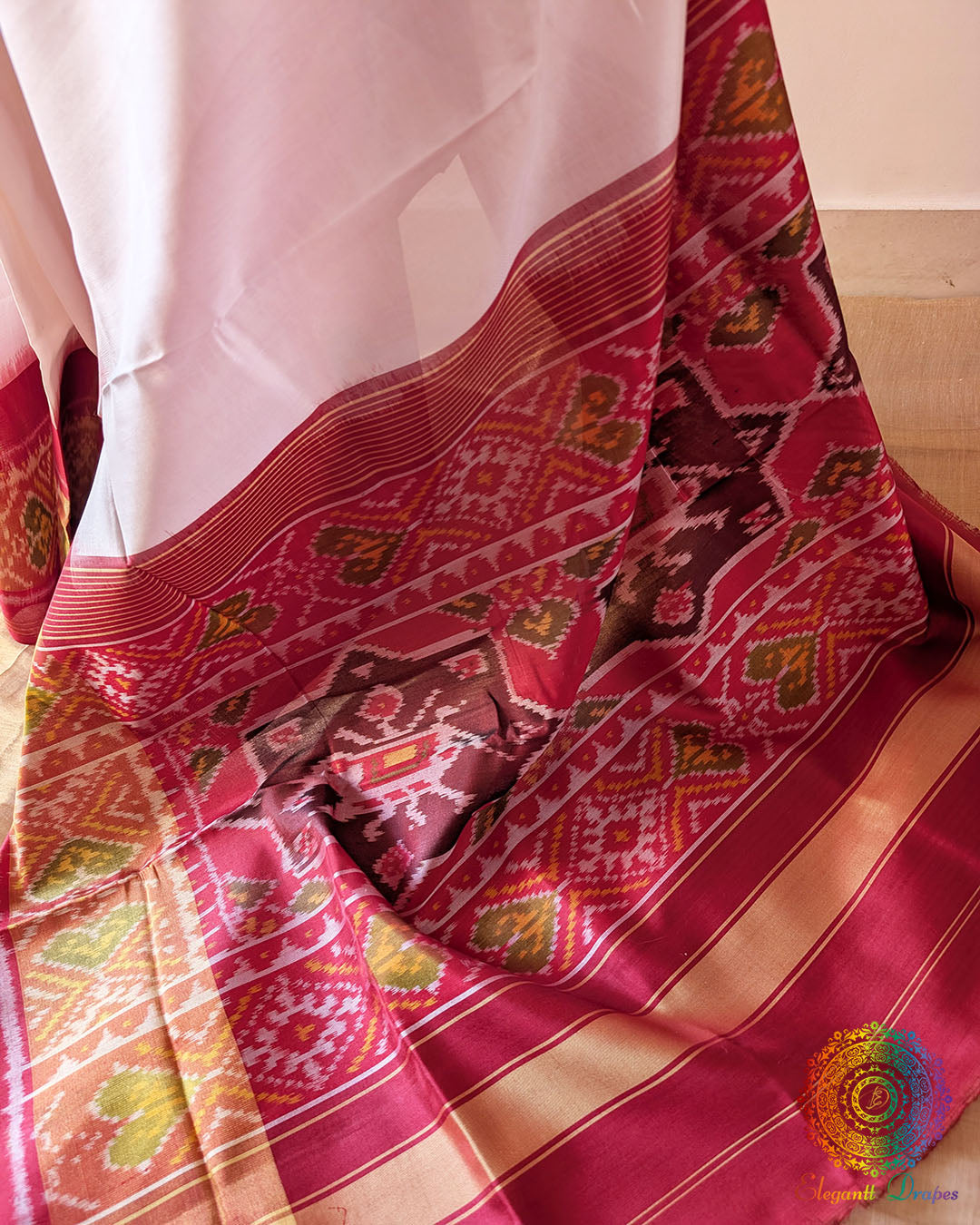 White Red Rajkot Patola Silk Saree – Red Palla Close-Up highlighting the rich red palla and its traditional woven detailing, complemented by the contrasting plain white body and fine mulberry silk texture.