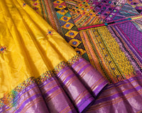 Purple border close up on yellow Ilkal silk saree highlighting embroidery