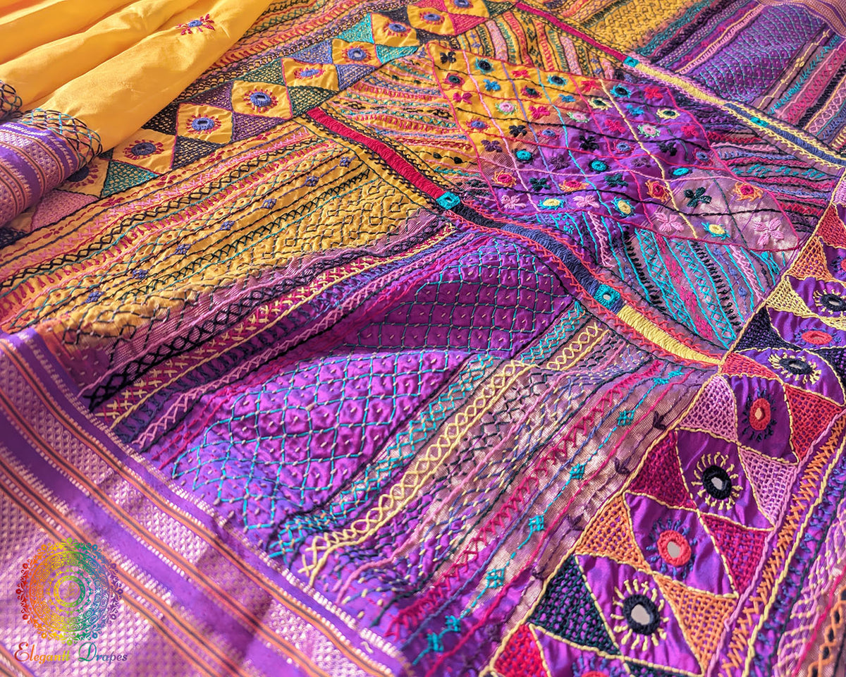 Purple palla close up on yellow Ilkal silk saree highlighting Lambani embroidery