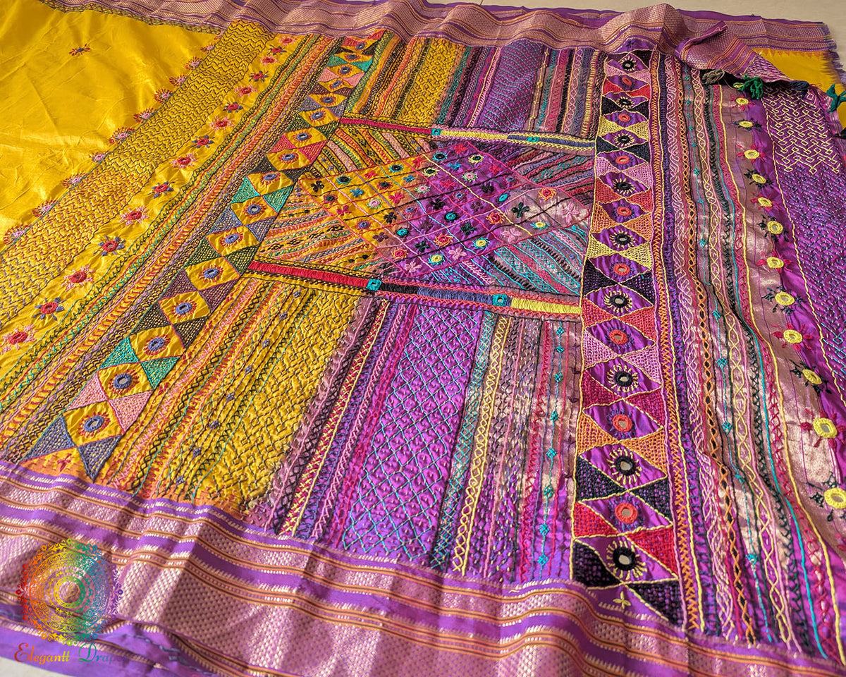 Intricate Lambani hand embroidery detail on yellow silk saree