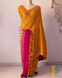 Mustard yellow gaji silk Bandhani saree showcasing graceful drape, red palla, and Nakshi border