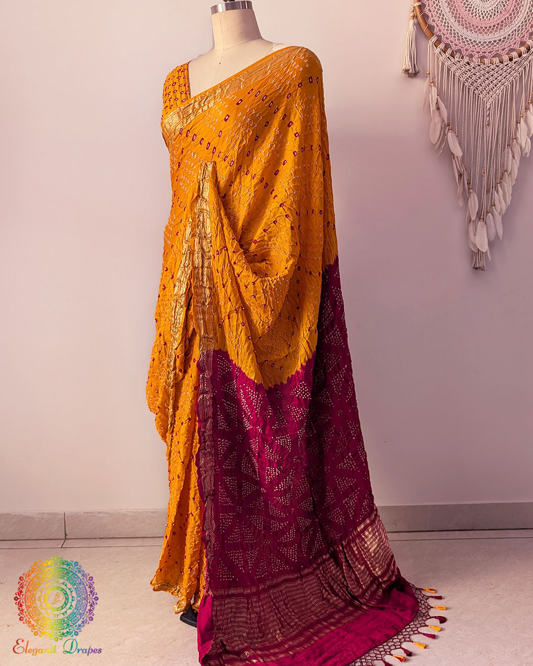 Red palla on mustard yellow gaji silk saree highlighting Bandhani craftsmanship and Nakshi border