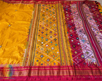Intricate Lambani hand embroidery detail on yellow silk saree