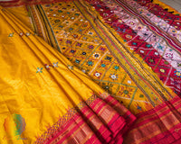 Red border close up on yellow Ilkal silk saree highlighting embroidery