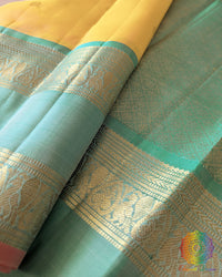 Yellow Pure Kanjivaram Silk Saree – Sea Green Zari Border Close-Up showcasing the traditional woven detailing along the sea green border and its contrast with the pale yellow silk body.