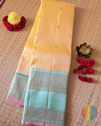 Yellow Pure Kanjivaram Handloom Silk Saree – Folded View showcasing the soft pale yellow silk body, delicate gold zari bootas and contrasting sea green border with traditional Kanjivaram weaving.
